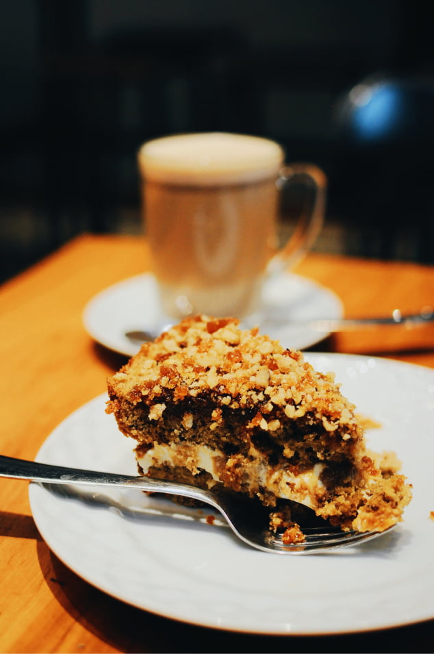 piece of cake with a latte coffee cup in background