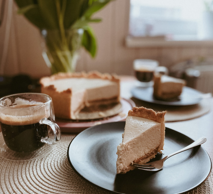 piece of cheesecake with a cup of coffee